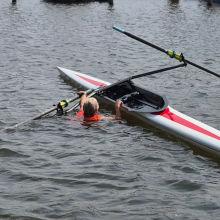 Roeiers naast de skiff